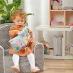 Sensorā grāmatiņa Seasons Babyono 1511 bērnam rokā