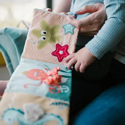 Divpusēja sensorā grāmatiņa Under the sea Babyono 1563 mazuļa roka